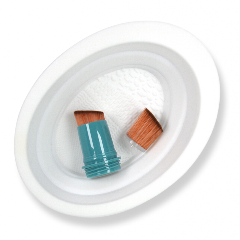 SUNNYBOD refillable brush heads in a wight silicone brush cleaning bowl. 